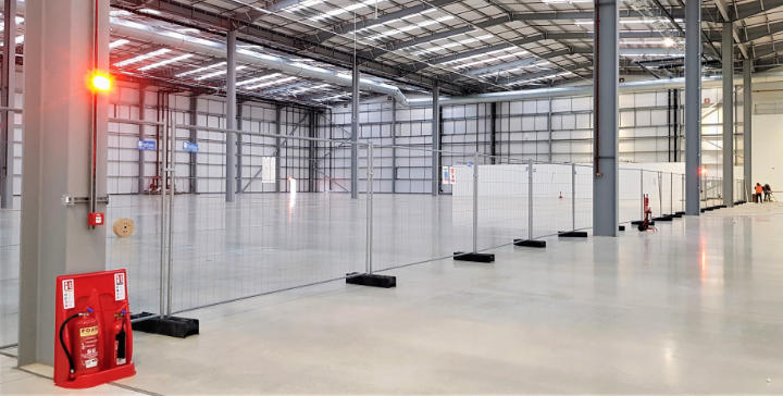 A photo of a fire extinguisher and alarm system installed in a warehouse